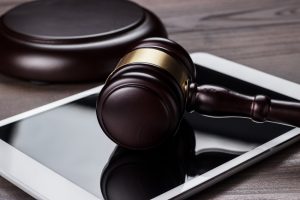 judge gavel and tablet computer on brown wooden backgroundjudge gavel and tablet computer on the table
