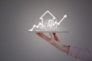 A simple house outline made of neon, being held up by a hand