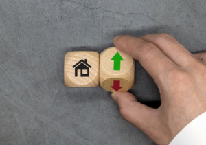 Two dice, one with a house and one with up and down arrows