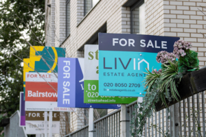 A row of for sale signs outside a block of flats