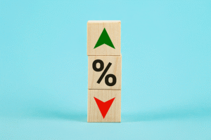 Three wooden bricks, one in the middle with a percentage sign, with a green arrow above and a red arrow below, set against a blue background