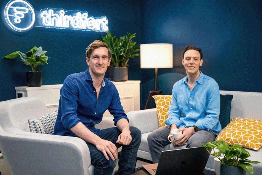The two co-founders of Thirdfort seated next to each other on grey sofas