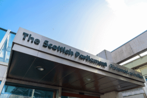 The entrance to the Scottish Parliament building taken from a close-up of the signage