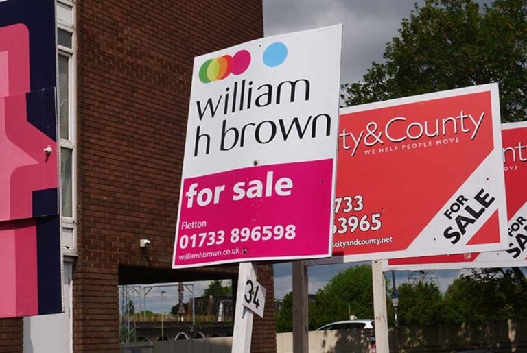 A row of for sale signs outside flats in Peterborough