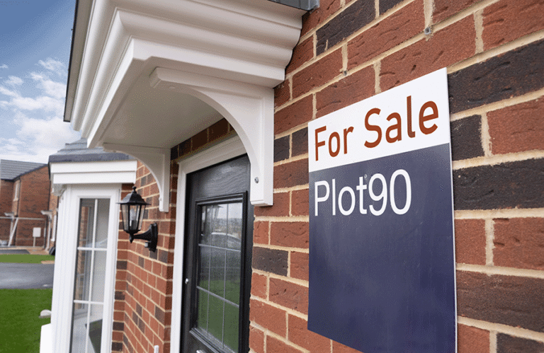 A newbuild house with a for sale side fixed to the front