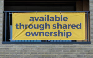 A banner with the words 'available through shared ownership' is strung across the outside of a building