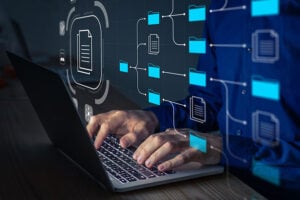 Holographic images of files linked together, hovering above a laptop to indicate digital documents