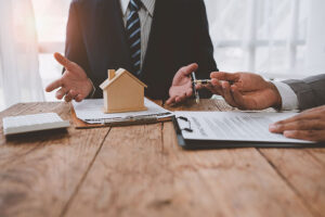 Close up of an estate agent and client sitting at a desk looking at paperwork