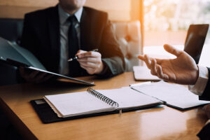 A lawyer and client look through a file of papers