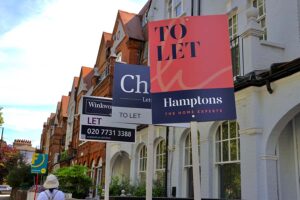 A row of terraced houses with 'to let' signs outside them