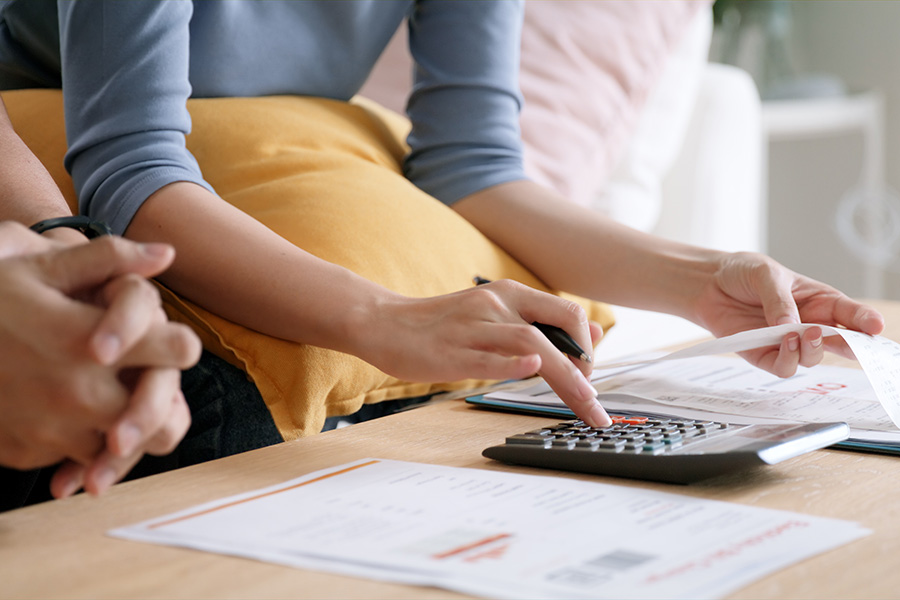 Close-up of a couple using a calculator and looking at bills