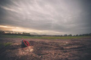 A green site for residential construction lies empty, with a roll of cables in the foreground