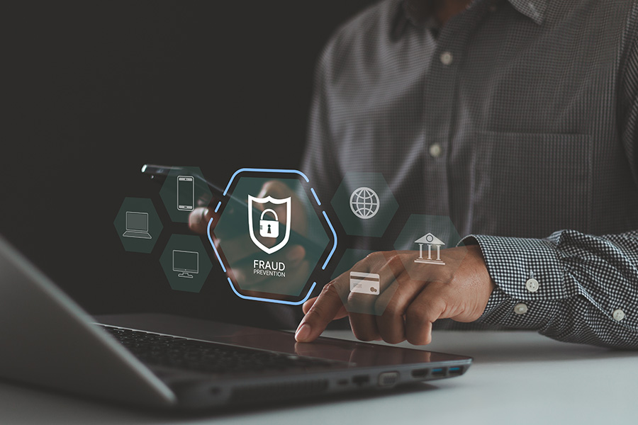 The word 'fraud' hovering above a laptop keyboard with a symbol of a lock
