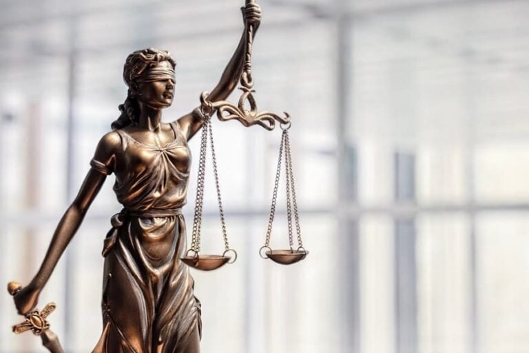 A bronze figurine of Lady Justice holding the scales of justice