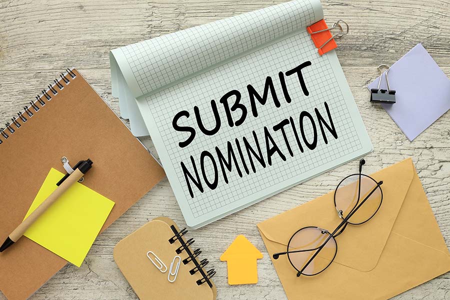 A notepad on a desk with the words 'submit nomination' written on it