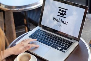 An open laptop with the word 'webinar' on the screen