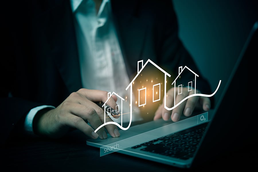 A graphic shows houses in neon outline above the keyboard of a laptop
