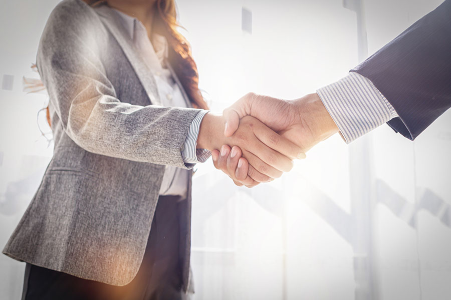 Close up of a couple in suits shaking hands