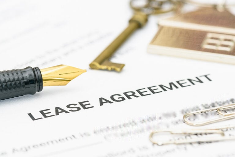 Papers headed with the words 'lease agreement' with a pen and key placed on top