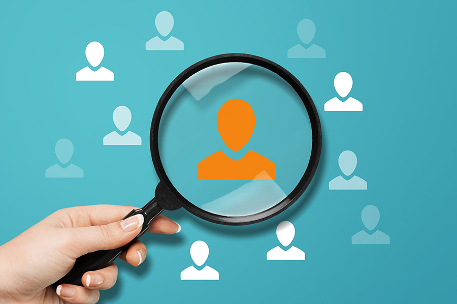 Basic outline shapes of people, with a magnifying glass over one of the shapes