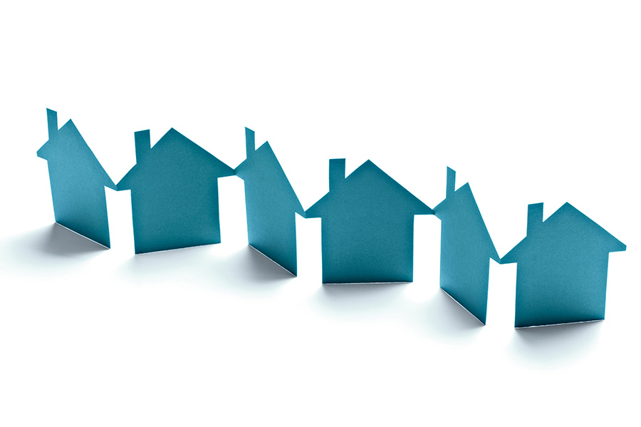 A chain of paper houses made of blue card against a white background