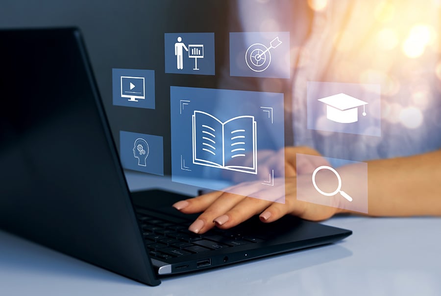 Graphics of open books and other learning symbols laid over a photo of hands on a laptop