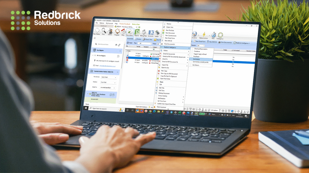 An open laptop on a desk, with the Redbrick logo on the top left corner