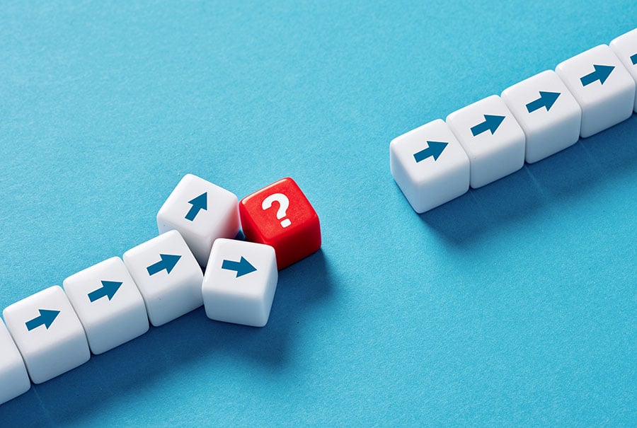 A row of neat arrows pointing upwards, disrupted half way up the line by a red question mark