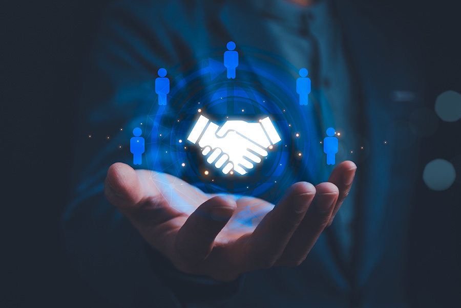 An outstretched hand appears to be holding a graphic of a handshake, which is surrounded by digital representations of people
