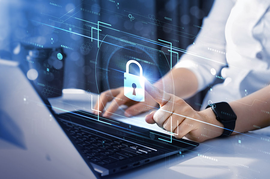 A graphic of a padlock is overlaid an image of a person typing on a laptop