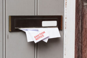 An envelope marked 'eviction notice' place through a letter box