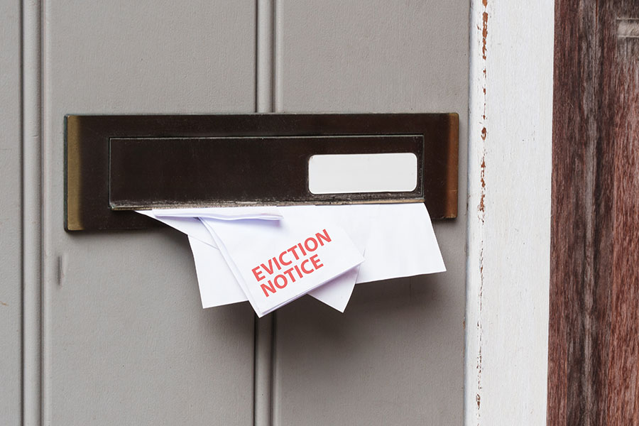 An envelope marked 'eviction notice' place through a letter box