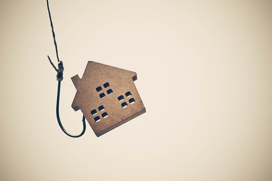 A hook on a line catching a small wooden house