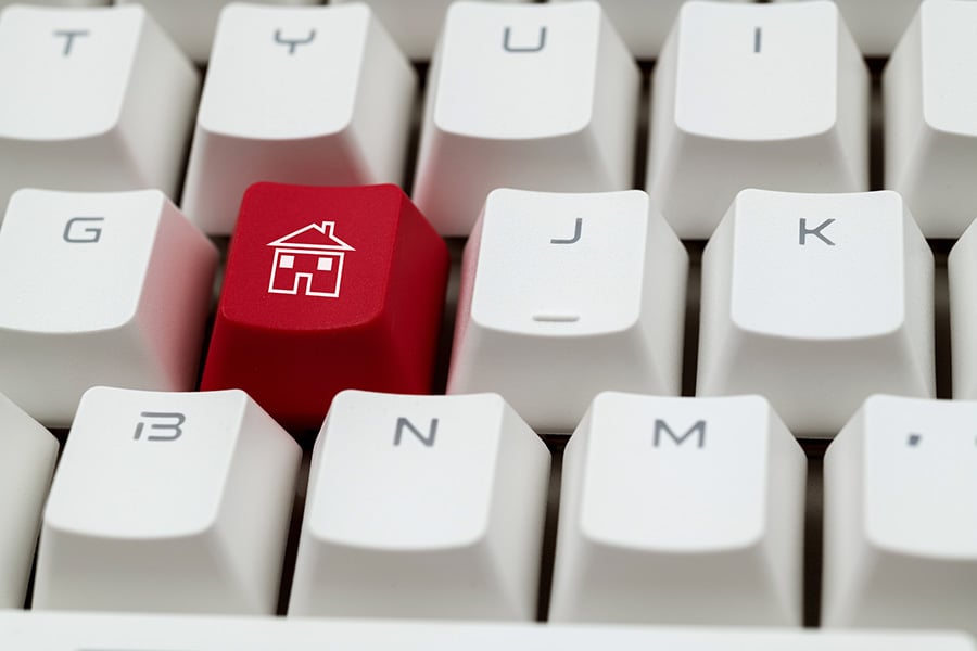 A computer keyboard with one of the keys featuring a house symbol