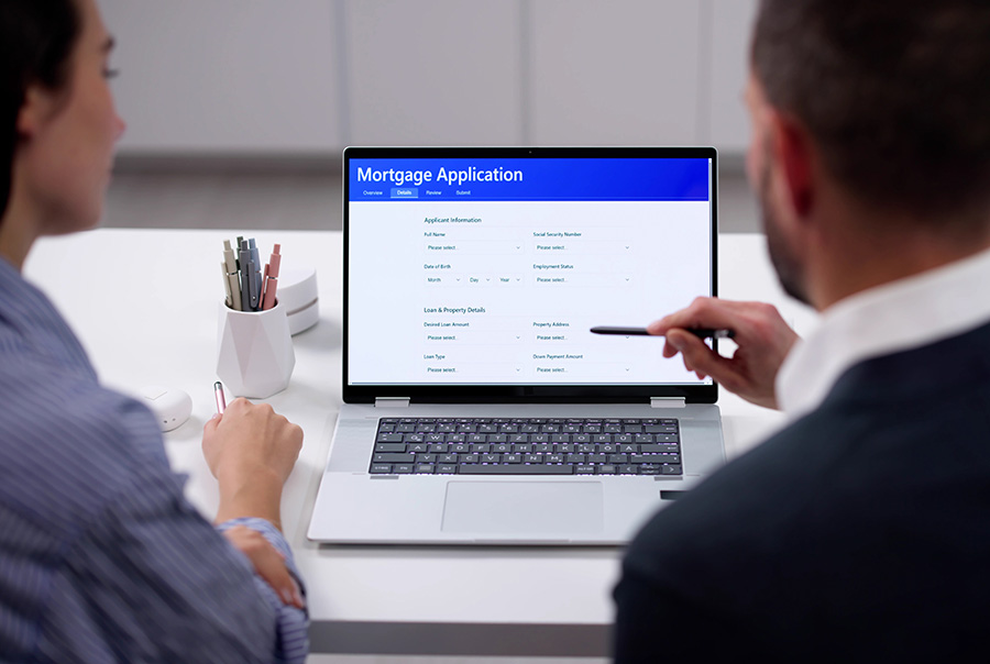 A couple look at a mortgage application on a laptop screen