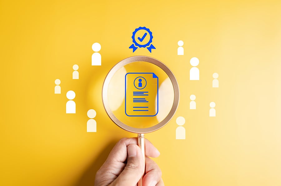 A magnifying glass held over a symbol of a certificate on a yellow background