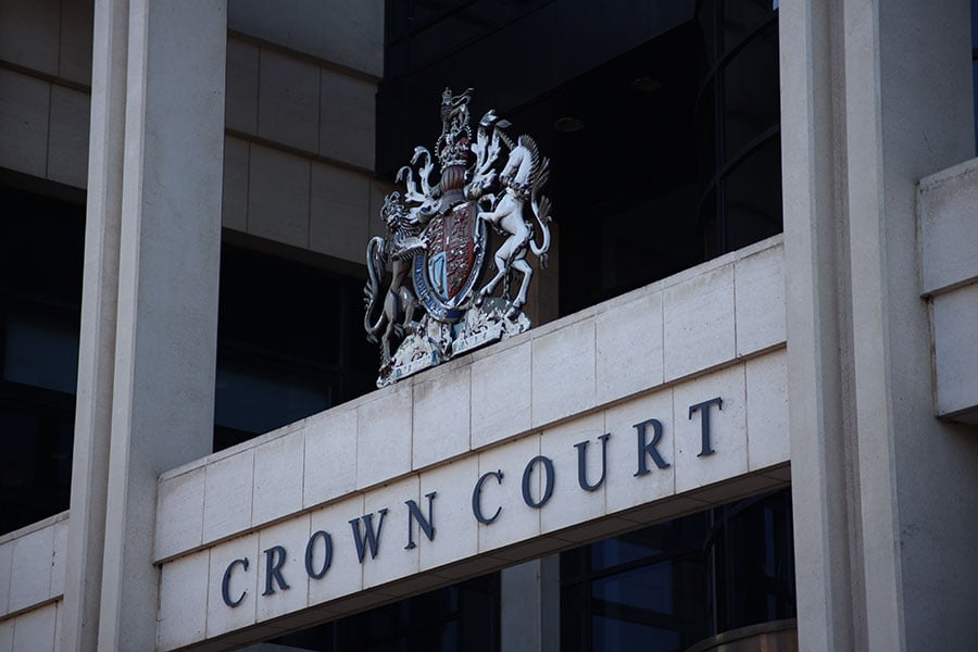 A close-up of a Crown Court sign and crest