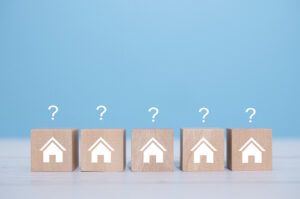 Four small blocks with houses printed on them, with question marks above each block