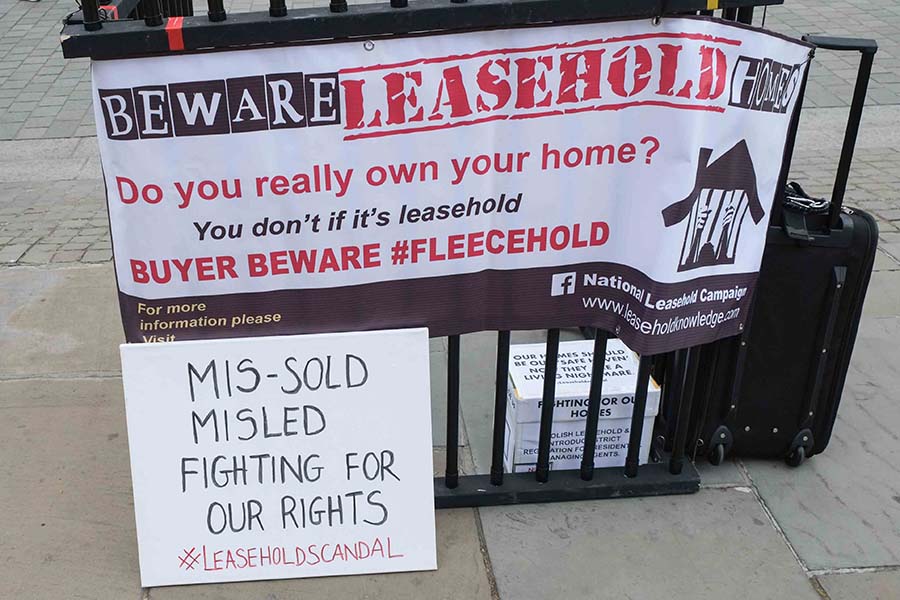 A campaign poster calling for leashold reform tied to railings