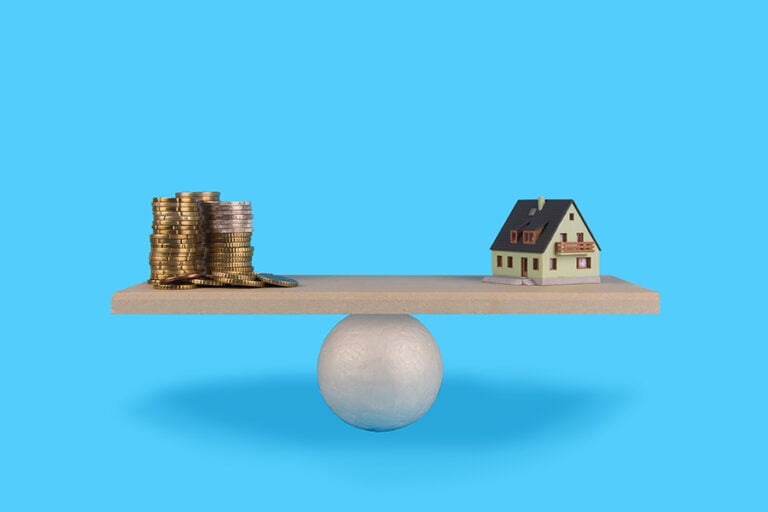 A seesaw is perfectly balanced with a house on one side and coins on the other