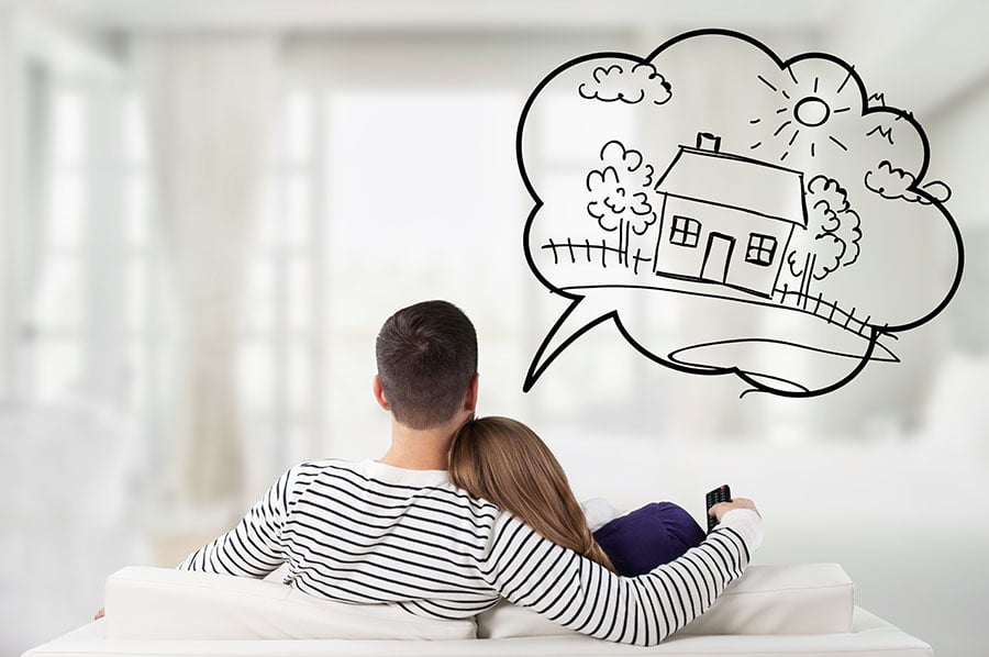 a couple on a sofa, seen from behind, with a drawn graphic of a dream bubble and a traditional home above them