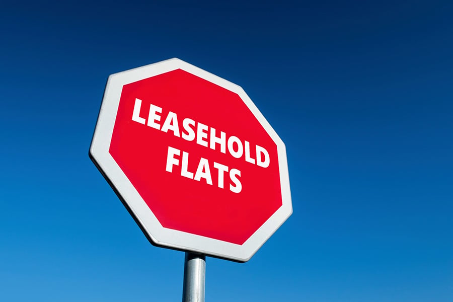 A red stop sign with the words 'leasehold flats' in white