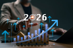 A blurred figure reaches out to touch a graphic of an upwards graph with the year 2026 above it
