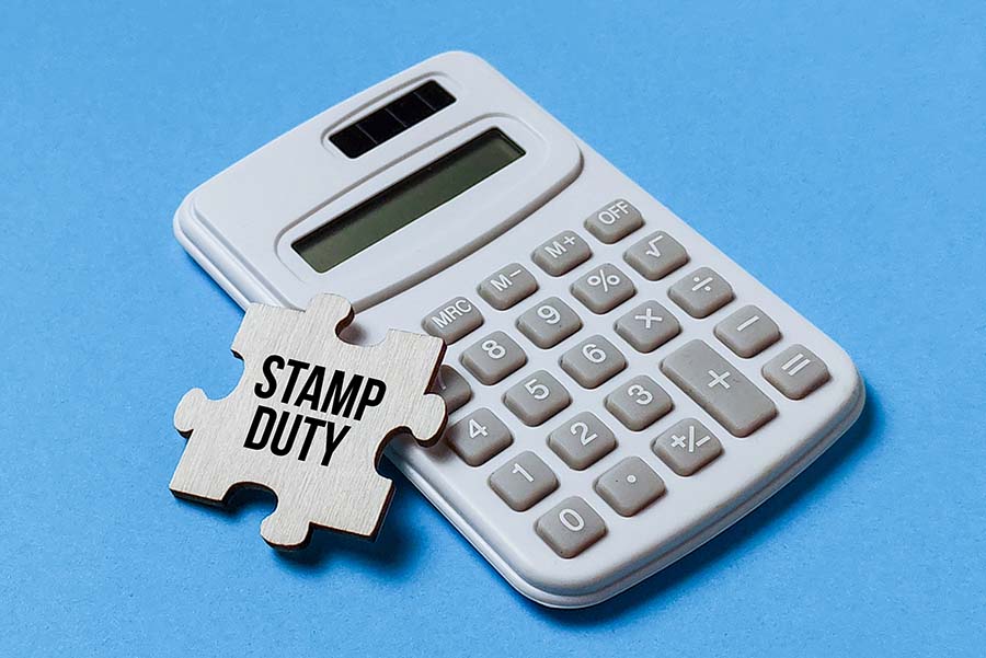 A calculator with a jigsaw piece on top of it bearing the words 'stamp duty'