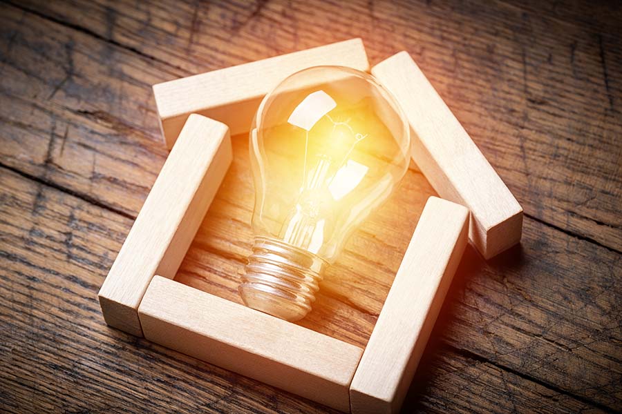A basic houseshape is outlined with pieces of wood, with a lightbulb placed in the centre