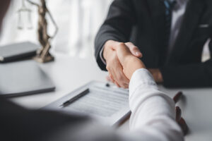 Close-up of a solicitor shaking hands with a client over a desk