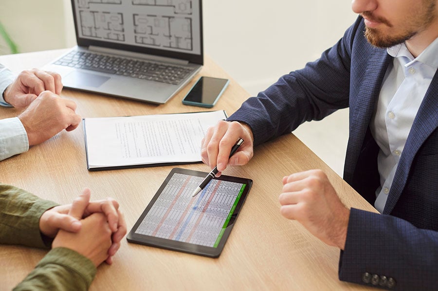 A financial adviser explaining rows of figures to two clients