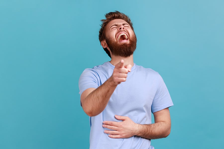 A laughing man holding his stomach