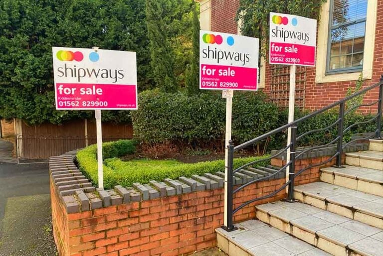 A row of identical for sale boards outside a block of flats
