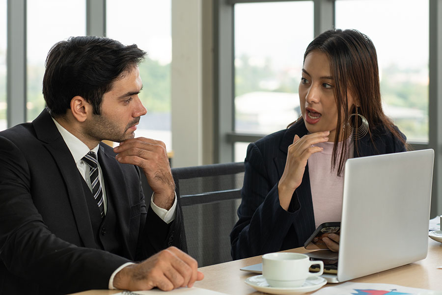 A professional couple talking over coffee
